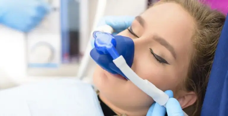 a woman is laying in a dental chair with an oxygen mask on her face .